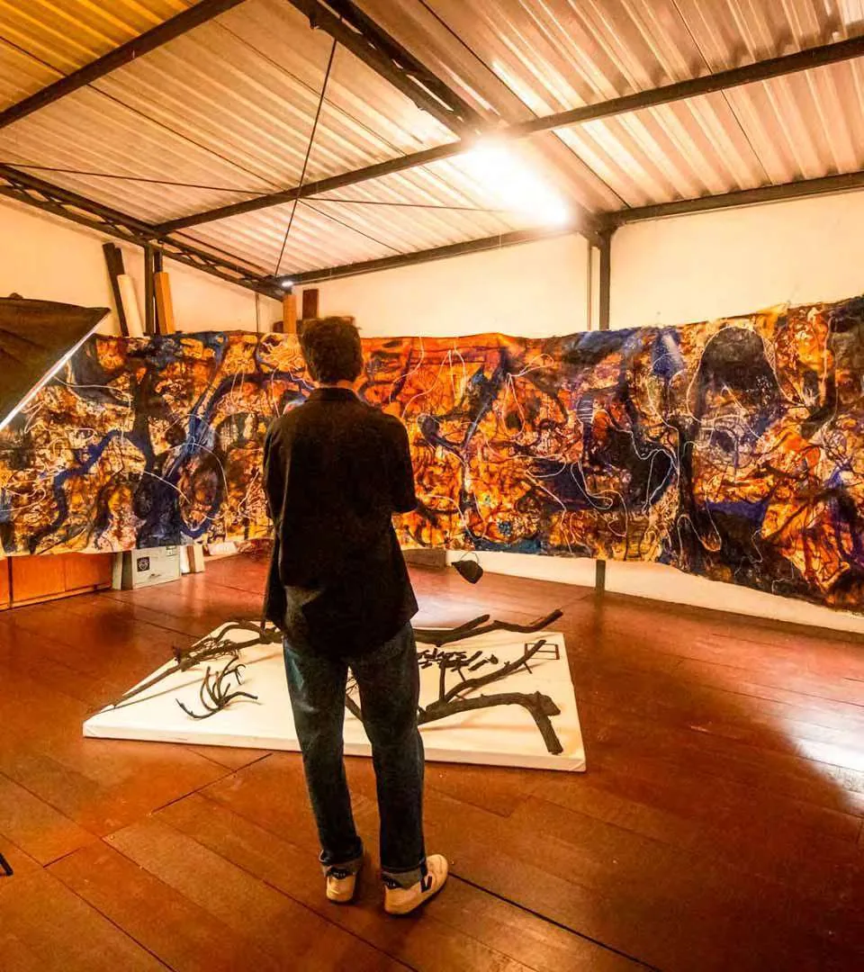 Visitante diante de obras em uma exposição na Casa Locomotiva